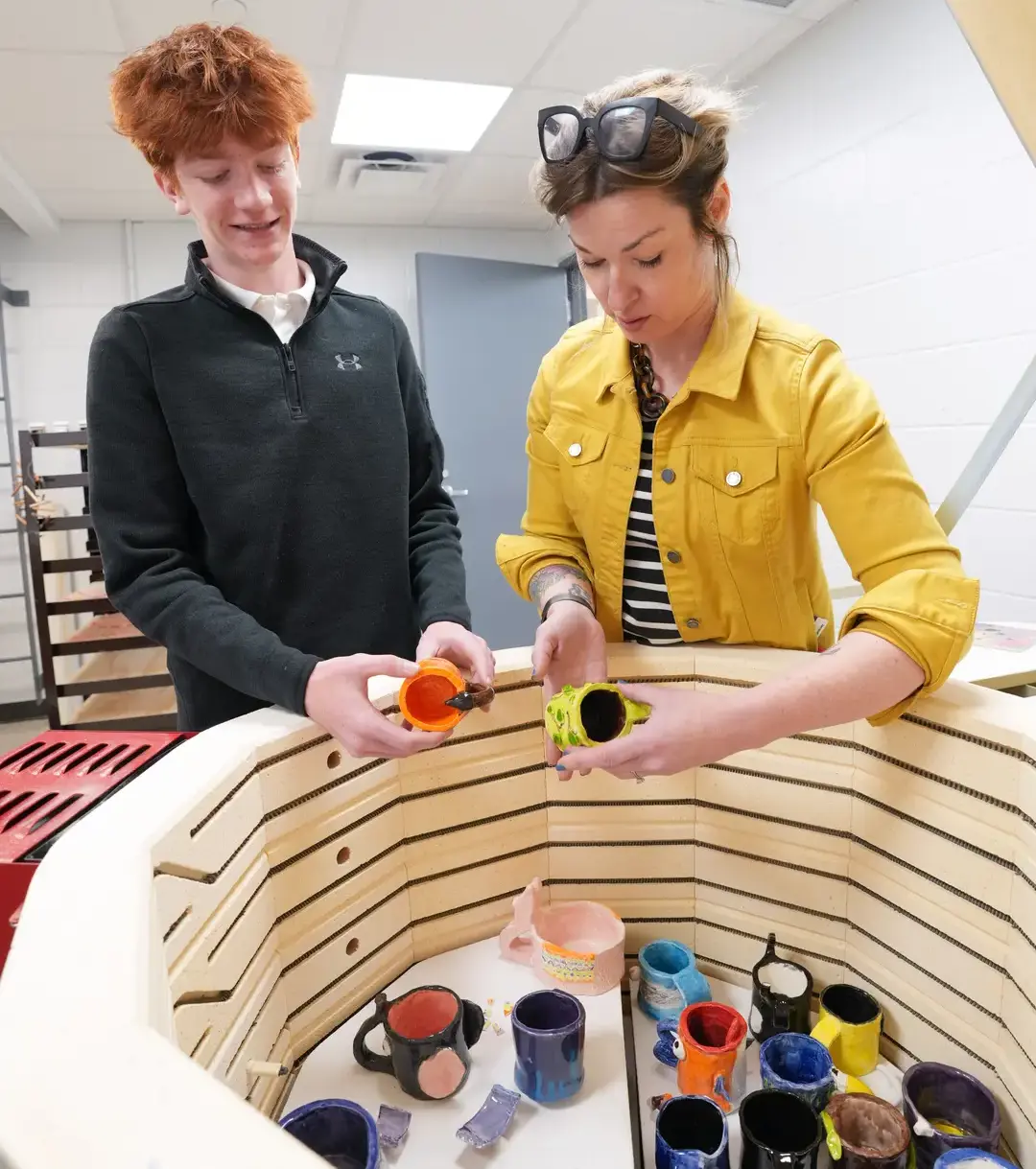 Teacher with student at the kiln