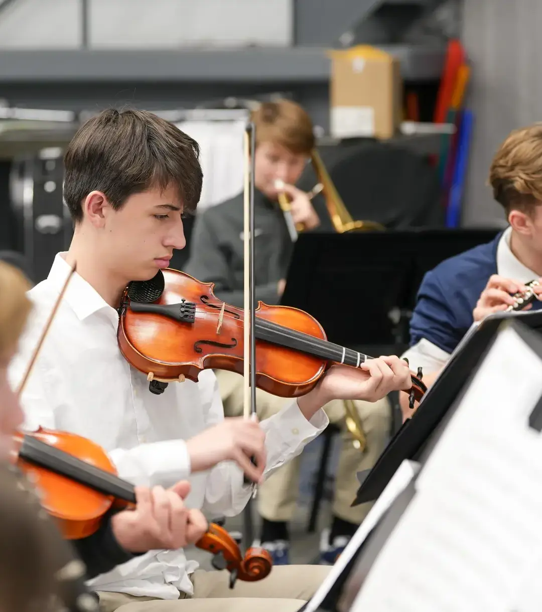 Student violinist playing as part of band