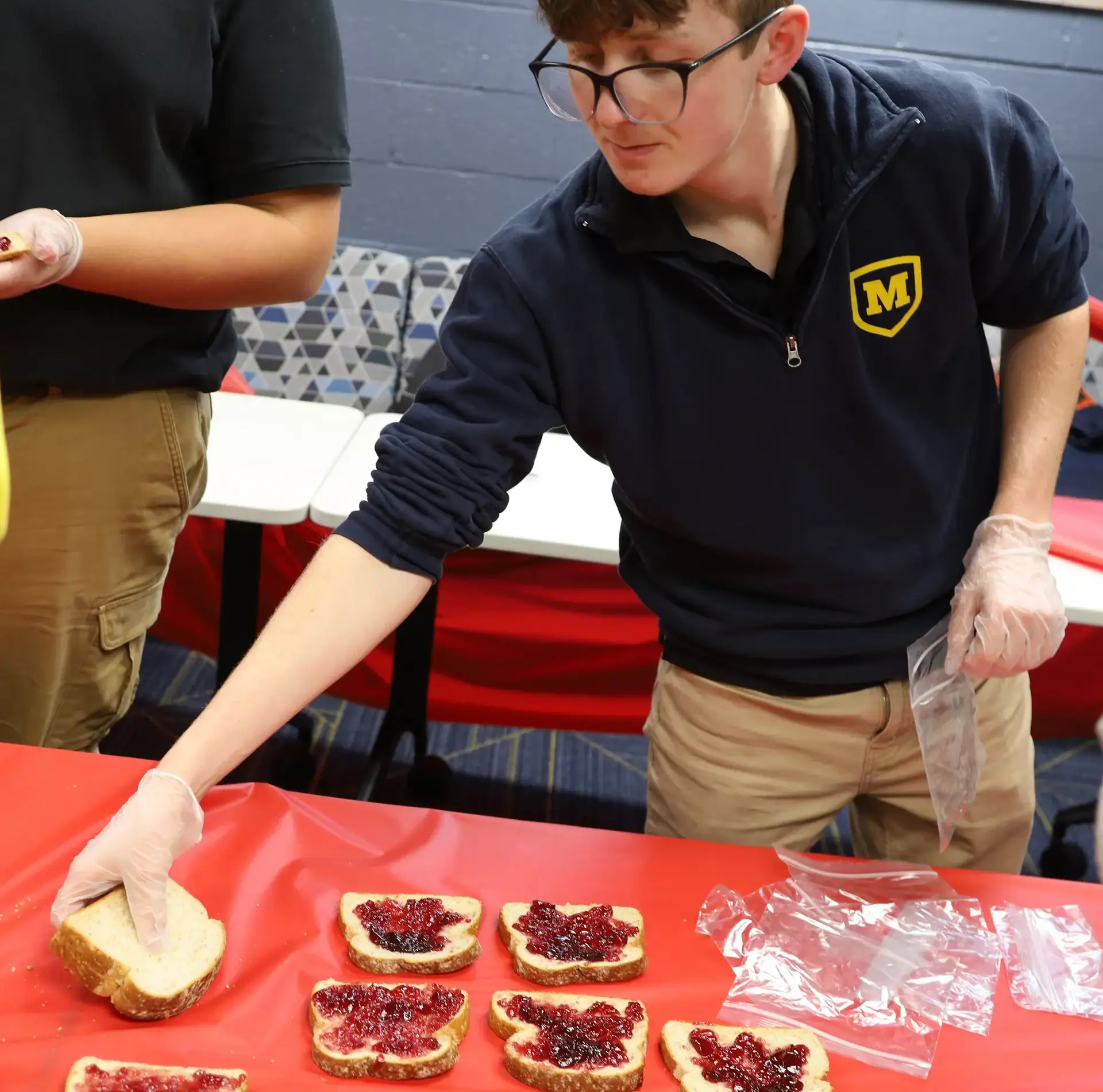 Student making sandwiches and setting them out at buffet table