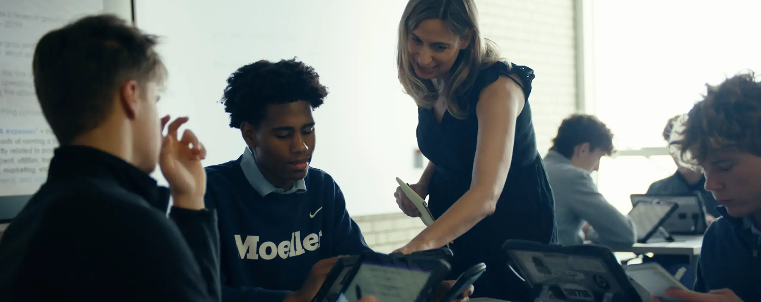 Teacher working with students in investment class