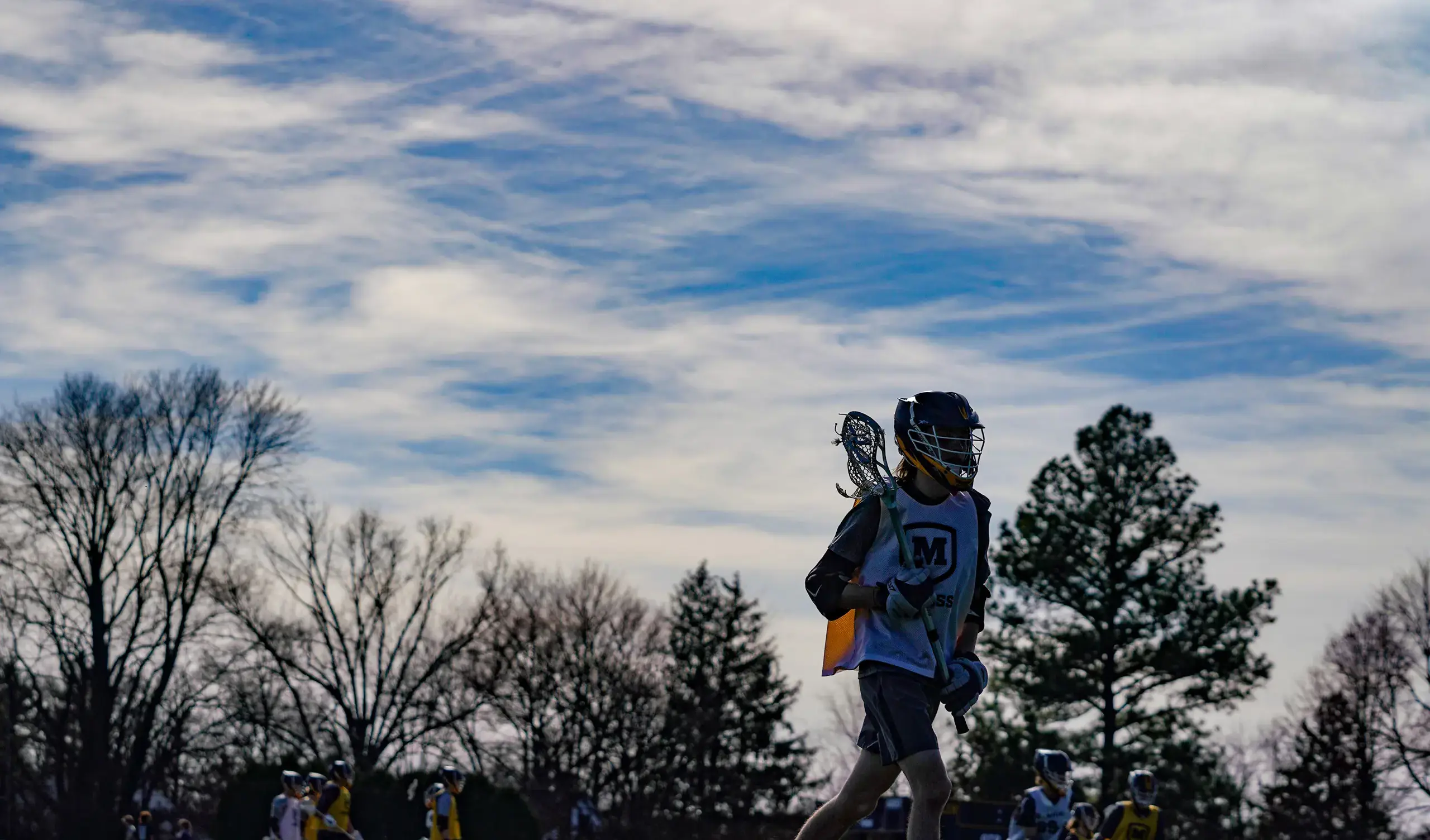 Lacrosse player on field at dusk